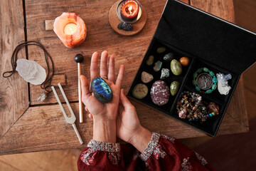 Cropped view of the fortune teller hands holding crystal at wooden table