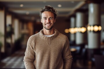Fototapeta premium Lifestyle portrait photography of a glad boy in his 30s wearing a cozy sweater against a swanky hotel lobby background. With generative AI technology