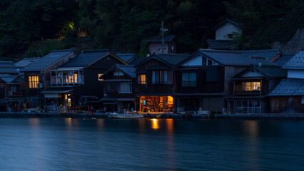 Fototapeta na wymiar Night view of traditional boathouses at Ine Town in Kyoto, Japan.