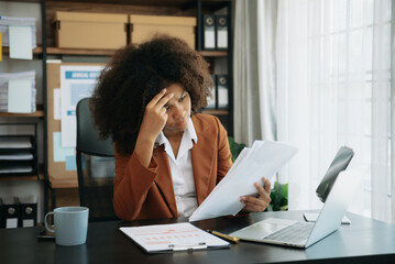 African business woman is stressed, bored, and overthinking from working on a tablet at the office.