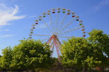 Ferris wheel against the blue sky in a summer park