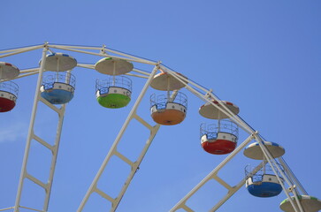 Ferris wheel against the blue sky in a summer park