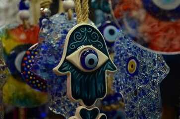 Nazar in market. Blue and red Fatima eye close-up protective amulet against evil eye. Israeli and...