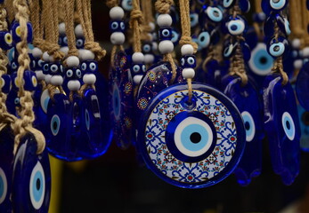 Nazar in market. Blue and red Fatima eye close-up protective amulet against evil eye. Israeli and turkish souvenir.  - obrazy, fototapety, plakaty