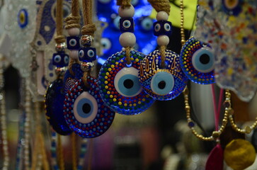 Nazar in market. Blue and red Fatima eye close-up protective amulet against evil eye. Israeli and...