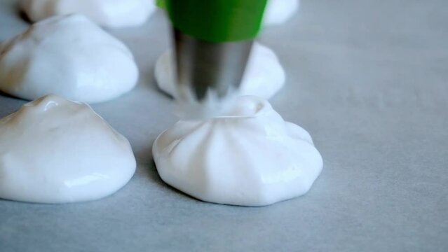 A piping bag that squeezes out the meringue. Close up. Cooking meringue.