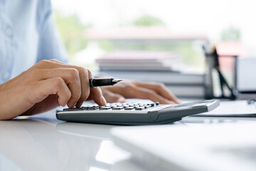 Obraz premium Woman working by using calculator.