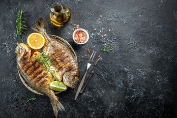 Baked fish dorado. Sea bream or dorada fish grilled on a dark background. top view