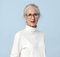 Elderly intelligent woman with glasses , with gray hair , a well-groomed face and  slight smile