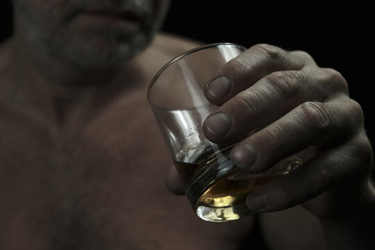 A man drinks from a glass. The man's face is not visible.