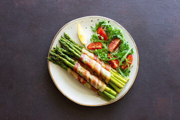 Asparagus baked with bacon and arugula and tomato salad. Healthy eating. Diet.