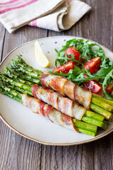 Asparagus baked with bacon and arugula and tomato salad. Healthy eating. Diet.