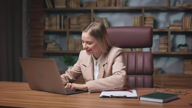 Female office worker feeling excited of getting notification on personal laptop about increasing salary. Attractive woman making surprise gesture and emotionally saying wow.
