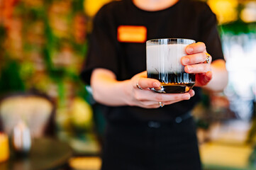 waiter hand hold cocktail glass in bar
