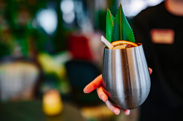 waiter hand hold cocktail glass in bar