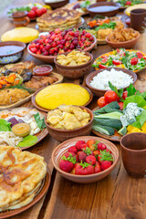 Homemade Romanian Food with grilled meat, polenta and vegetables Platter on camping. Romantic traditional moldavian food outside on the wood table.