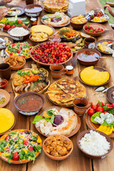Homemade Romanian Food with grilled meat, polenta and vegetables Platter on camping. Romantic traditional moldavian food outside on the wood table.