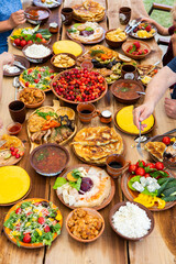 Homemade Romanian Food with grilled meat, polenta and vegetables Platter on camping. Romantic traditional moldavian food outside on the wood table.