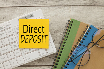 direct deposit text on yellow sticker on white keyboard. Business concept image - obrazy, fototapety, plakaty