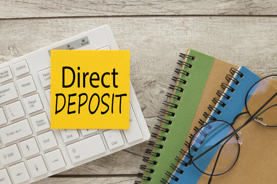 direct deposit text on yellow sticker on white keyboard. Business concept image