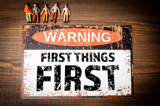 First things first. Warning sign with text on wood texture background
