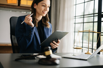 justice and law concept.Male judge in a courtroom  the gavel, working with smart phone and laptop...