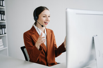 Serious call center operator in wireless headset talking with customer, woman in headphones with microphone consulting client on phone in customer support service in office center..