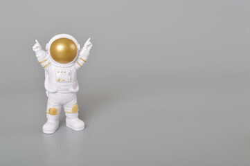 Astronaut toy in action isolated on a grey background.