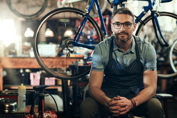 Fototapeta na wymiar Portrait, mechanic and man in bicycle shop, store and cycling workshop for repairs. Entrepreneur, bike technician and mature male person, small business owner and retail service expert from Canada