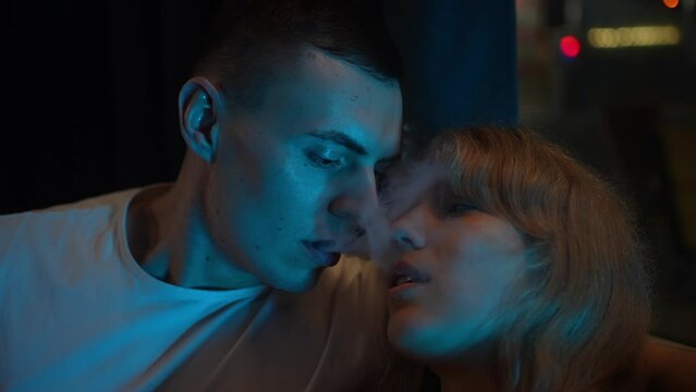 Couple in love smoking hookah in night club