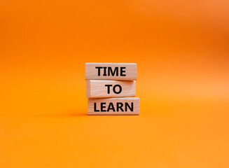 Time to learn symbol. Wooden blocks with words Time to learn. Beautiful orange background. Business...