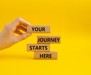 Your Journey starts here symbol. Concept word. Your Journey starts here on wooden blocks. Beautiful yellow background. Businessman hand. Business and Your Journey starts here concept. Copy space