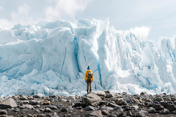 A man posing on the ice formation of the Perito Moreno glacier, Argentina - obrazy, fototapety, plakaty