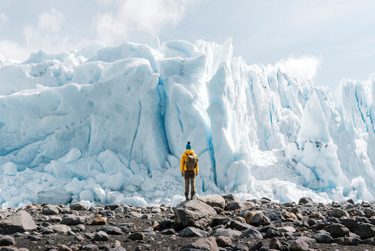 A man posing on the ice formation of the Perito Moreno glacier, Argentina - Powered by Adobe