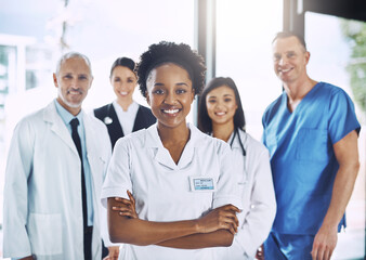 Fototapeta premium Smile, team and portrait of black woman with doctors, nurses and diversity in hospital with teamwork in healthcare. Health, support and boss, confident doctor with group of medical employees together
