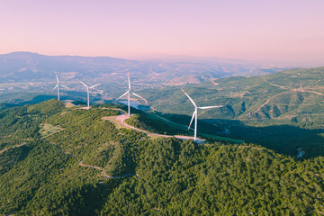 Wind turbines spinning in the wind energy station in mountain. Aerial view