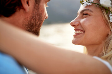 Close up portrait shot of joyful bride with big smile looking at her husband. Couple by seaside. Wedding, travel, honeymoon, love concept