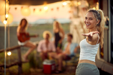 A young sexy girl at the campsite is posing for a photo during a vacation in the nature with her friends. Vacation, friendship, camping, nature © luckybusiness