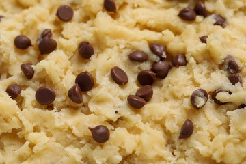 Raw dough for chocolate chip cookies as background, closeup