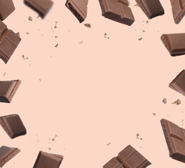 Frame of falling pieces of chocolate bar on beige background, space for text