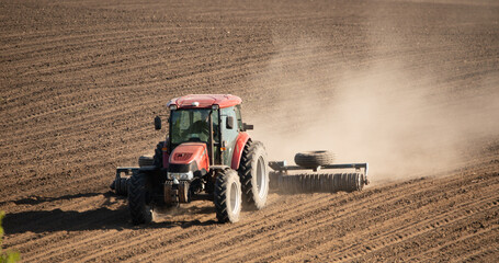 Obraz premium Tractor cultivating field: farming in action selective focus