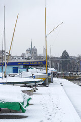 Bateaux de plaisance couverts de neige dans la rade de Genève en hiver