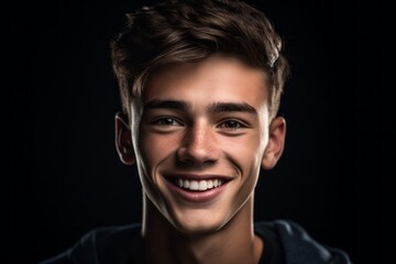 Fototapeta premium Headshot portrait photography of a grinning boy in his 20s giving a hug to the camera against a matte black background. With generative AI technology