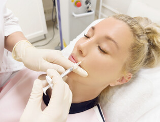 Fototapeta premium Hyaluronic acid injections for specific areas.Lip augmentation with hyaluronic acid fillers,using flexible hyaluronic acid fillers