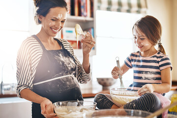 Mother, playful or kid baking in kitchen as a happy family with an excited girl laughing or...
