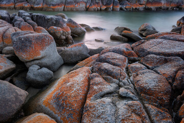 Long exposure of the red lichen covered rocks at Binalog Bay, Bay of Fires, Tasmania.