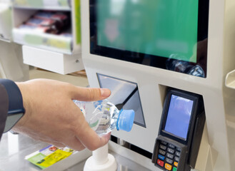 Customer pays his purchase at the supermarket,self checkout systems in  retail stores,Barcode scanner,Self checkout machine