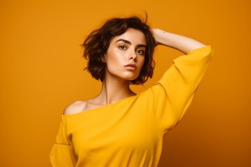 Close-up portrait photography of a beautiful girl in her 20s extending arms to one side in a gesture of freedom against a yellow background. With generative AI technology