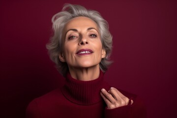Close-up portrait photography of a satisfied mature woman blowing air kisses at camera against a burgundy red background. With generative AI technology
