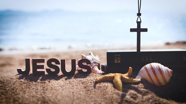 Bible book and cross of Jesus Christ on sea sand beach and church summer retreat and summer bible school summer camp
